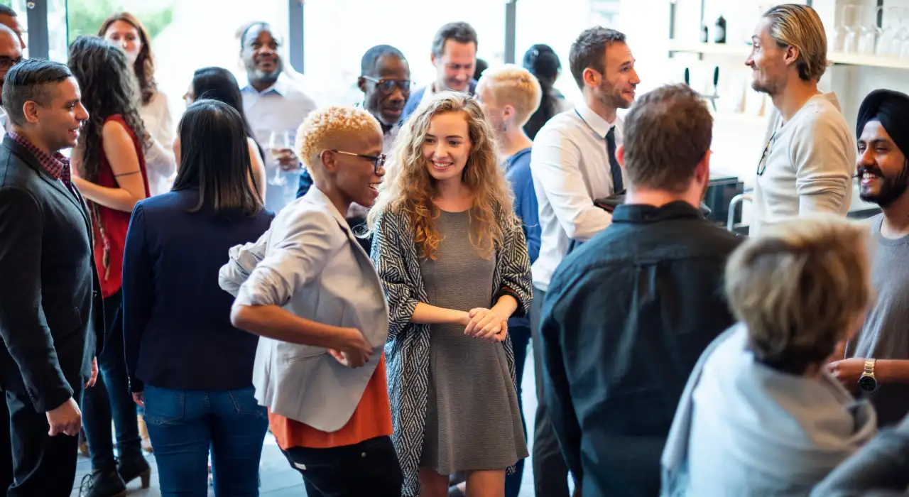 A lively group of people socializing and networking at a supporter event indoors.