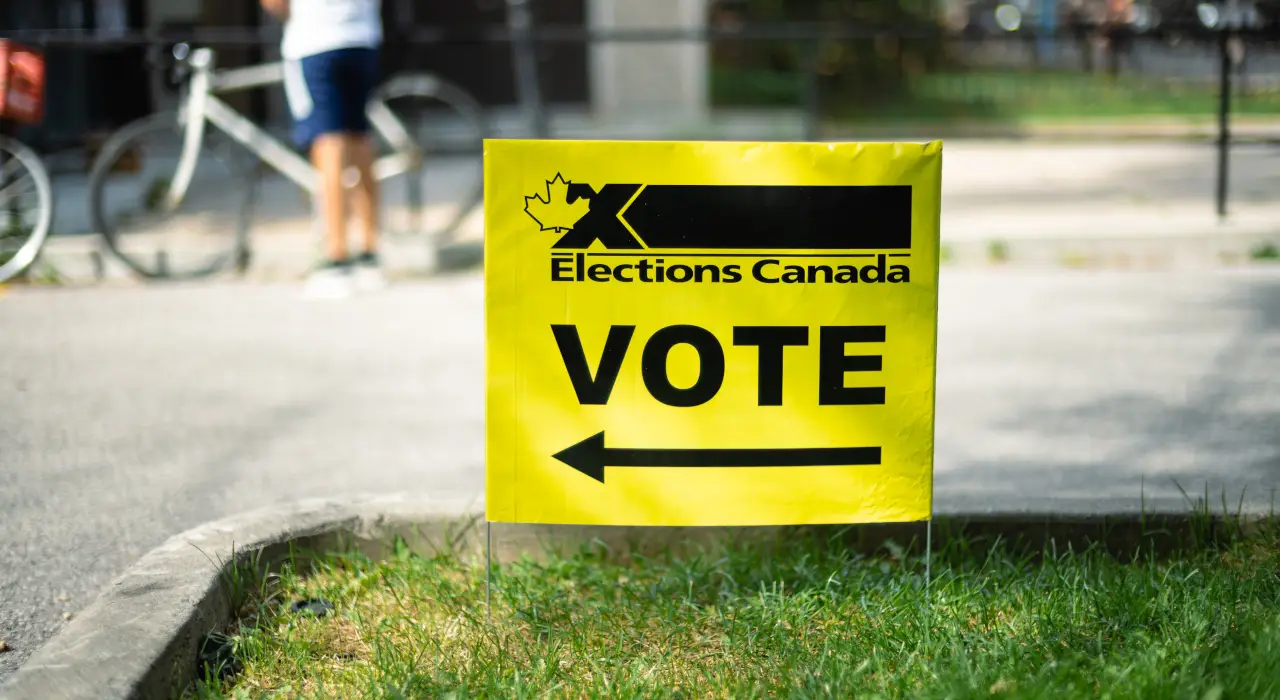 明亮的黃色加拿大選舉局標誌，上面寫有「VOTE」。
