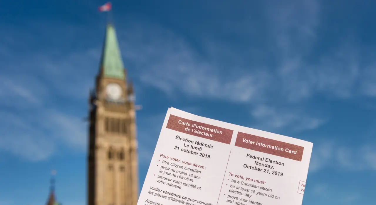 ਕੈਨੇਡਾ ਦੀ ਸੰਸਦ ਦੀ ਪੀਸ ਟਾਵਰ ਸਾਹਮਣੇ ਫੜ੍ਹੀ ਹੋਈ ਵੋਟਰ ਜਾਣਕਾਰੀ ਕਾਰਡ।