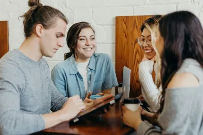 Young people discussing and smiling at a café table